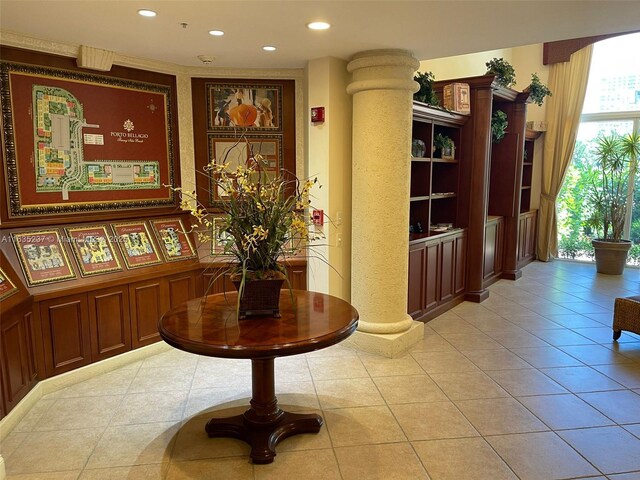 corridor featuring decorative columns and light tile patterned floors