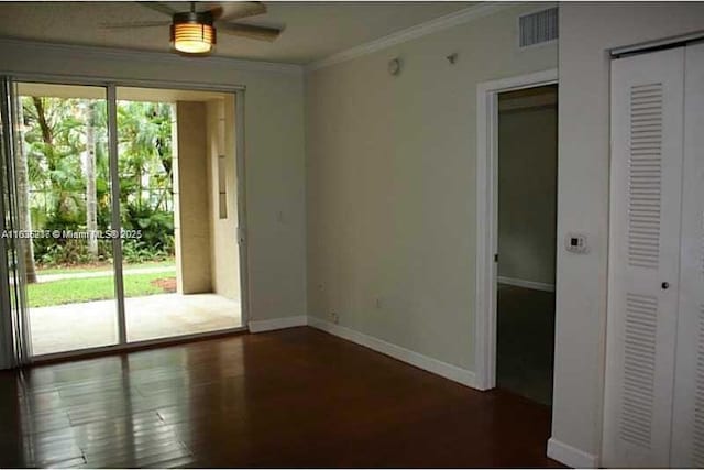 spare room featuring ceiling fan, dark wood-type flooring, and ornamental molding