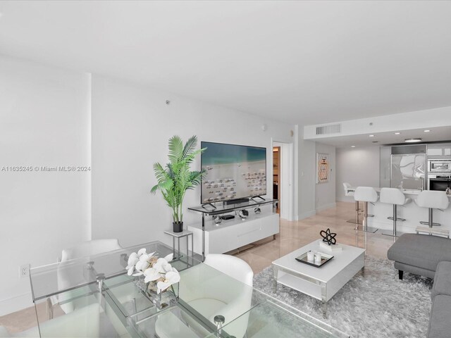 living area featuring baseboards and visible vents