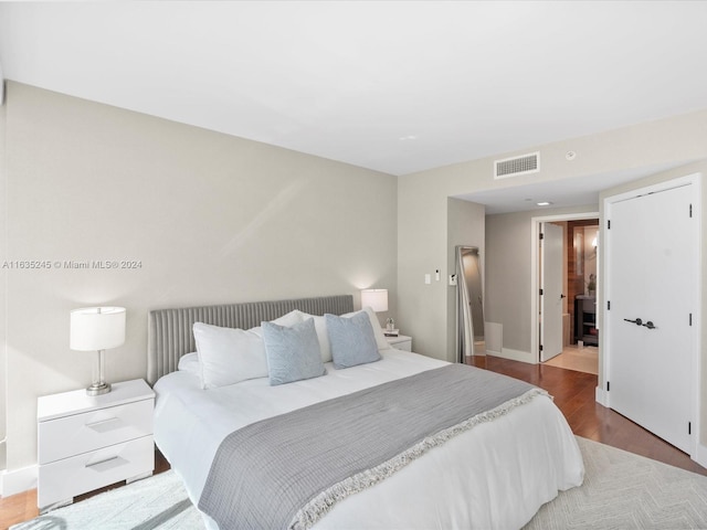 bedroom featuring baseboards, visible vents, and wood finished floors