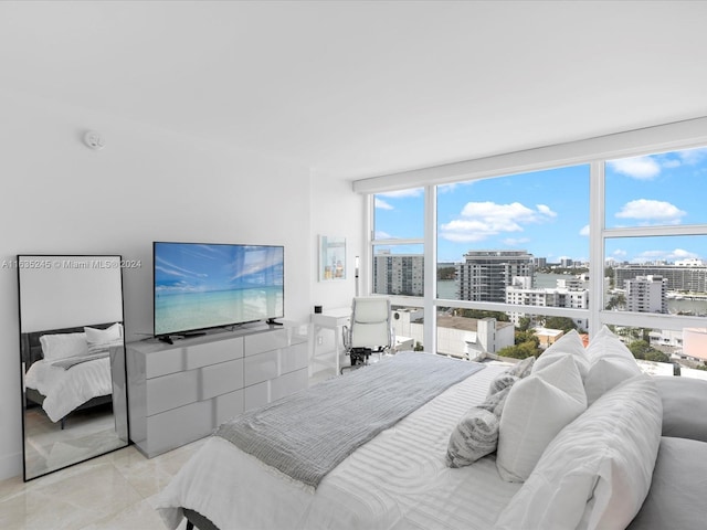 bedroom with expansive windows and light tile patterned floors