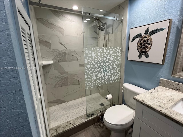 bathroom featuring toilet, wood-type flooring, an enclosed shower, and vanity