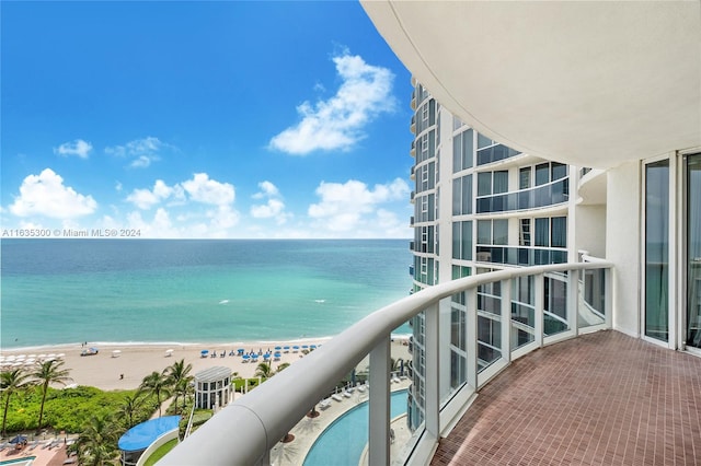 balcony with a water view and a beach view