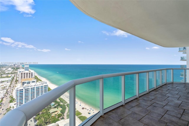 balcony featuring a water view and a view of the beach