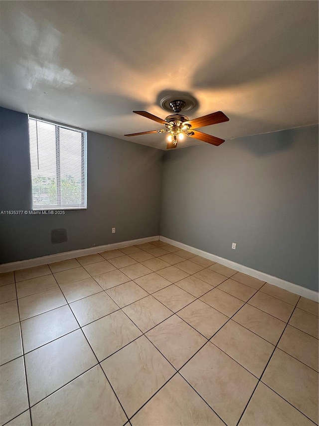 unfurnished room featuring a ceiling fan and baseboards