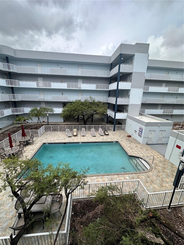 community pool featuring a patio area and fence