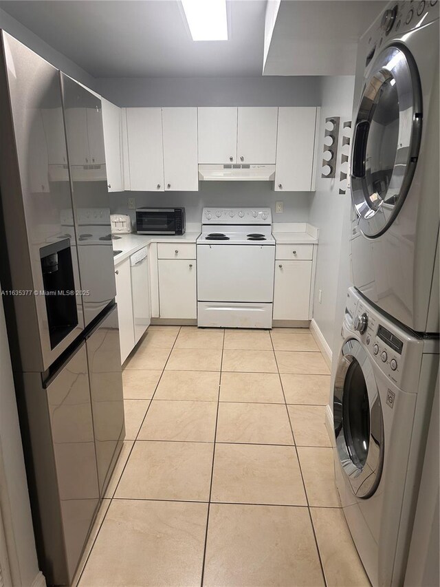 interior space featuring stacked washer / dryer, white cabinetry, white appliances, and light tile patterned floors