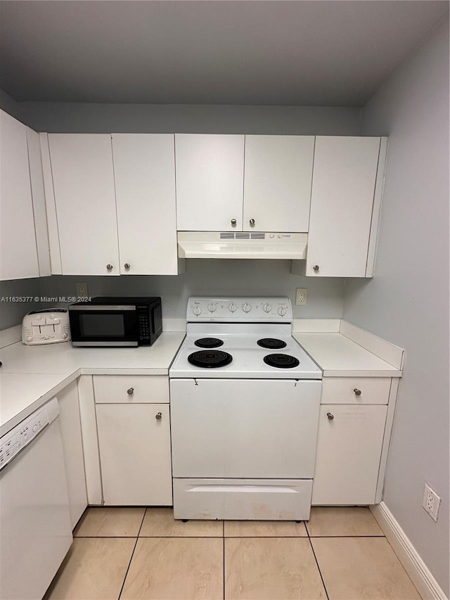 kitchen with light tile patterned flooring, white appliances, and white cabinets