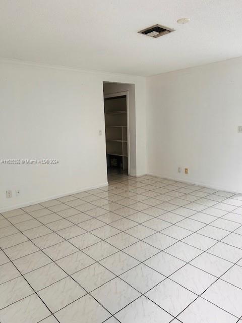 empty room featuring crown molding