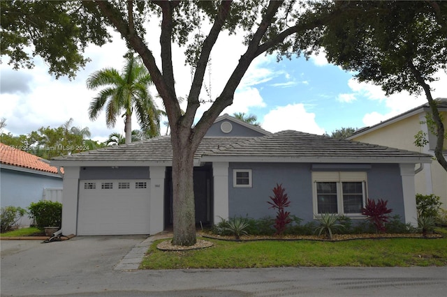 ranch-style house with a garage and a front lawn