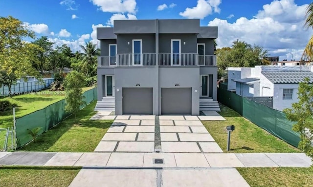 contemporary house featuring a balcony, a garage, and a front yard