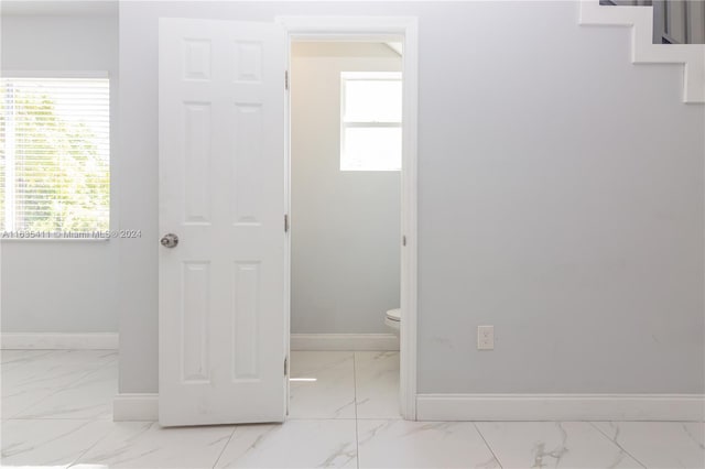 interior space featuring baseboards and marble finish floor