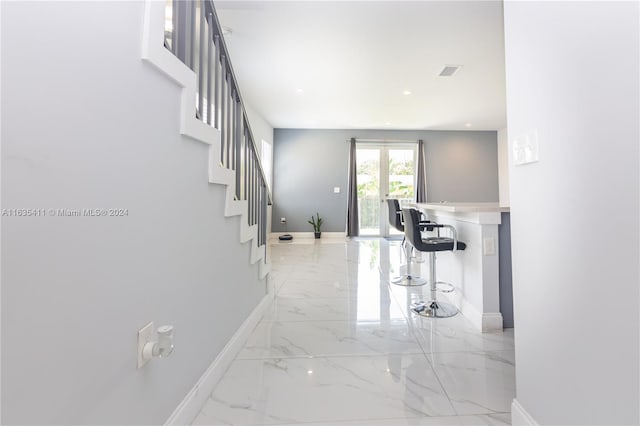 hall with visible vents, baseboards, stairway, recessed lighting, and marble finish floor