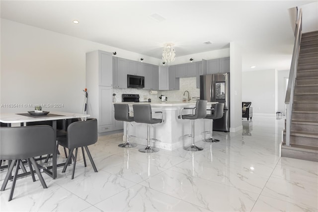 kitchen with marble finish floor, gray cabinets, a breakfast bar area, and smart refrigerator