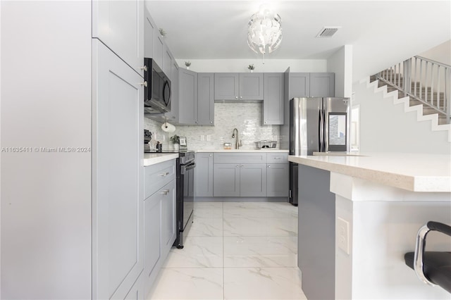 kitchen featuring visible vents, light countertops, gray cabinets, marble finish floor, and black appliances