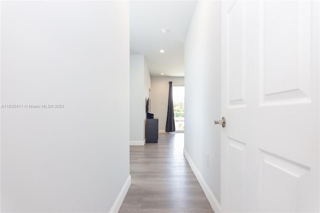 corridor featuring recessed lighting, baseboards, and wood finished floors