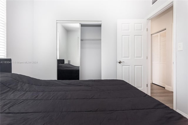 unfurnished bedroom featuring a closet, visible vents, and wood finished floors