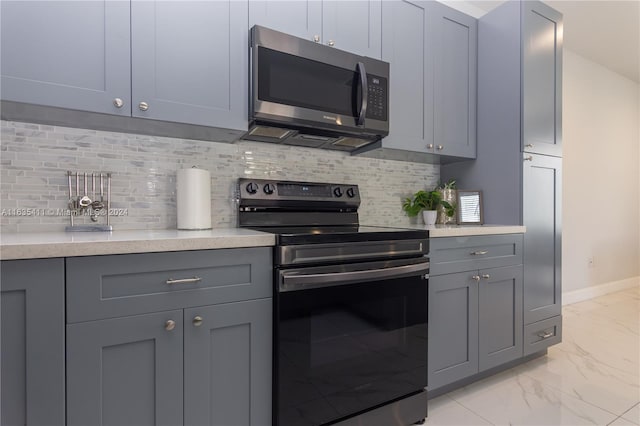 kitchen featuring stainless steel microwave, marble finish floor, electric range, and gray cabinetry