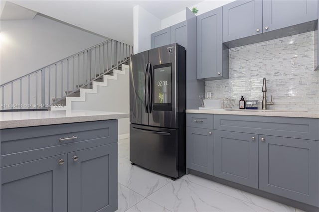 kitchen featuring gray cabinets, a sink, smart refrigerator, marble finish floor, and backsplash