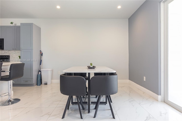 dining room with recessed lighting, marble finish floor, and baseboards