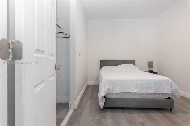 bedroom with wood finished floors and baseboards