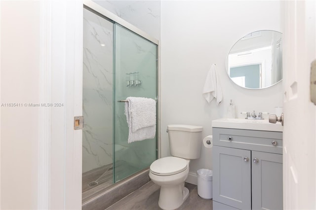 full bathroom with a marble finish shower, toilet, vanity, and baseboards