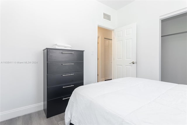 bedroom featuring visible vents, baseboards, and wood finished floors