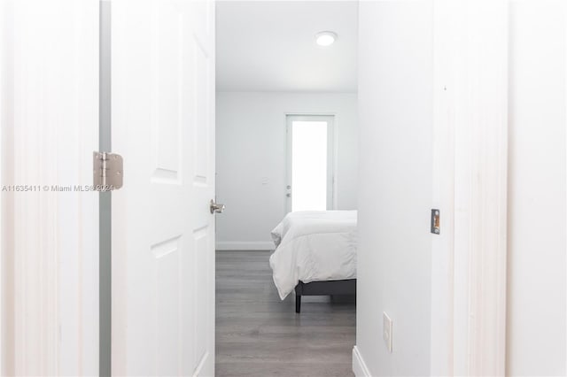 corridor featuring wood finished floors and baseboards