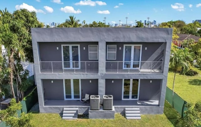 rear view of property featuring a patio area, a balcony, french doors, and central AC