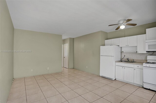 kitchen featuring white appliances, light tile patterned flooring, backsplash, ceiling fan, and white cabinets