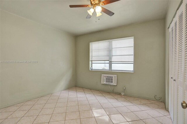 unfurnished bedroom featuring ceiling fan, light tile patterned flooring, a wall unit AC, and a closet