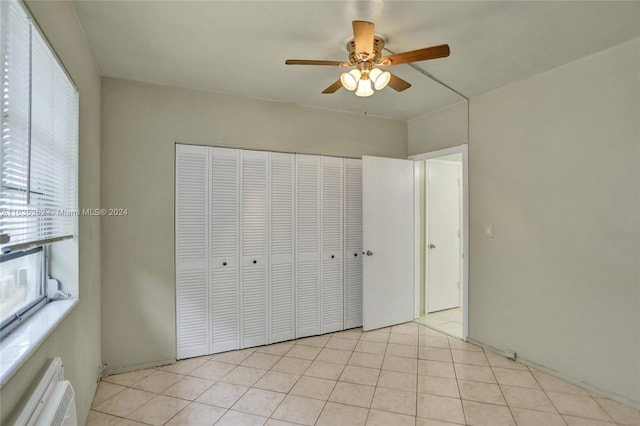 unfurnished bedroom featuring ceiling fan, a closet, and light tile patterned flooring