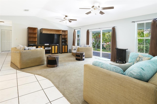 living room with ceiling fan, lofted ceiling, and light tile patterned flooring