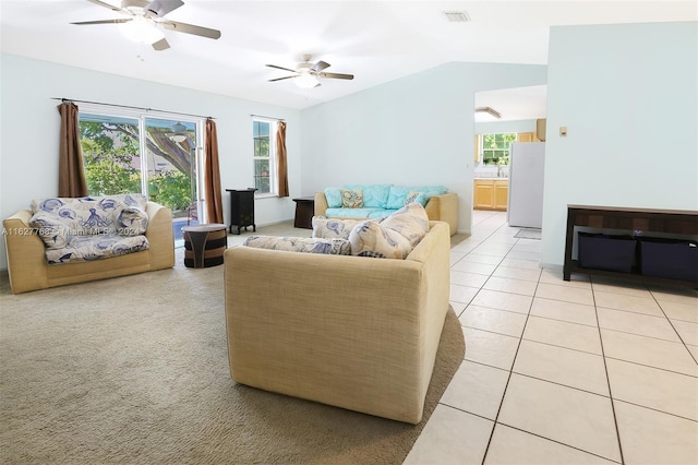 tiled living room featuring ceiling fan and vaulted ceiling