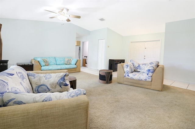 carpeted living room with ceiling fan and vaulted ceiling