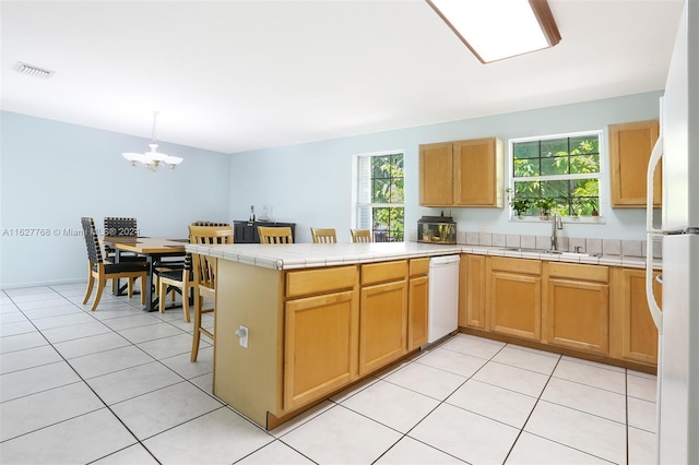 kitchen with kitchen peninsula, white appliances, a healthy amount of sunlight, and sink