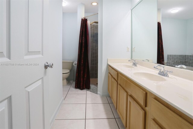 bathroom with tile patterned floors, vanity, toilet, and walk in shower