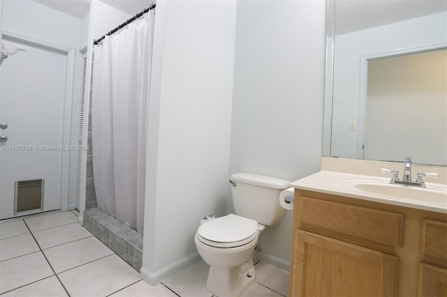 bathroom featuring tile patterned flooring, vanity, a textured ceiling, and toilet