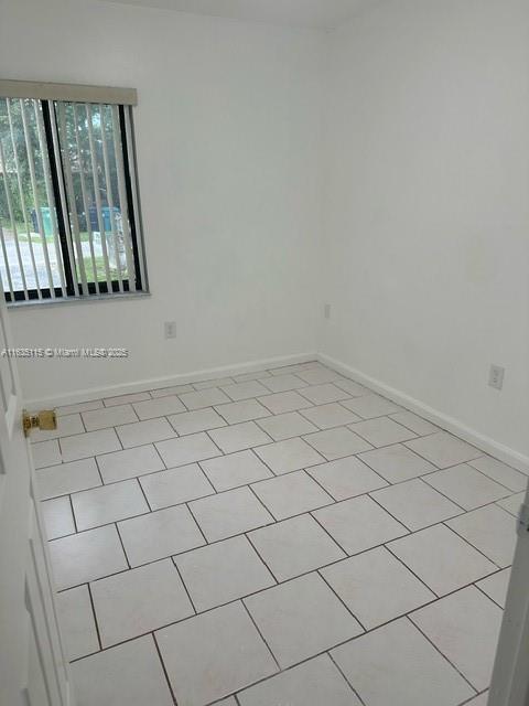 spare room featuring light tile patterned flooring