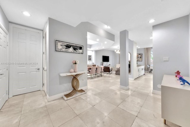 tiled entryway with a chandelier