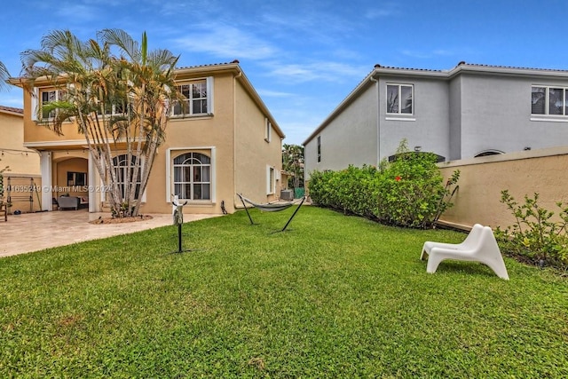 rear view of property with a yard and a patio area