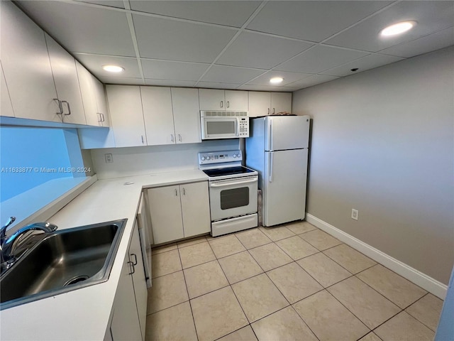 kitchen featuring a drop ceiling, sink, white cabinetry, and white appliances