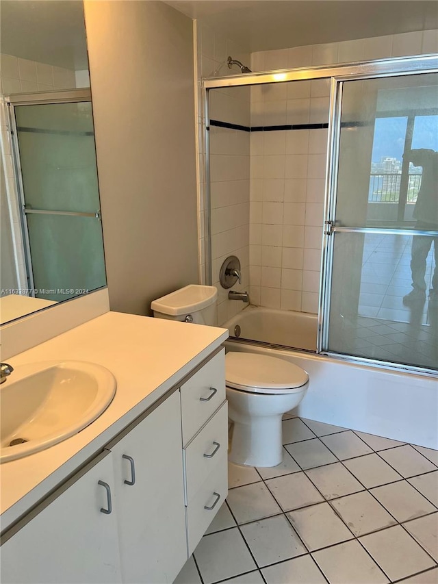 full bathroom with tile patterned flooring, combined bath / shower with glass door, toilet, and vanity