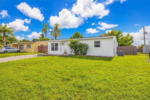 ranch-style house featuring a front lawn and central AC unit