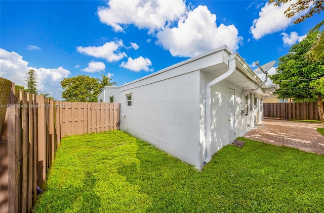 view of side of property with a lawn and a patio area