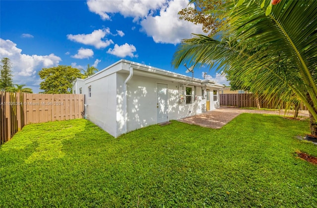 back of property featuring a yard and a patio area