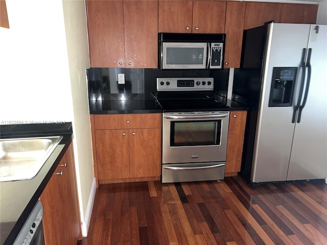 kitchen with sink, appliances with stainless steel finishes, decorative backsplash, and dark hardwood / wood-style floors