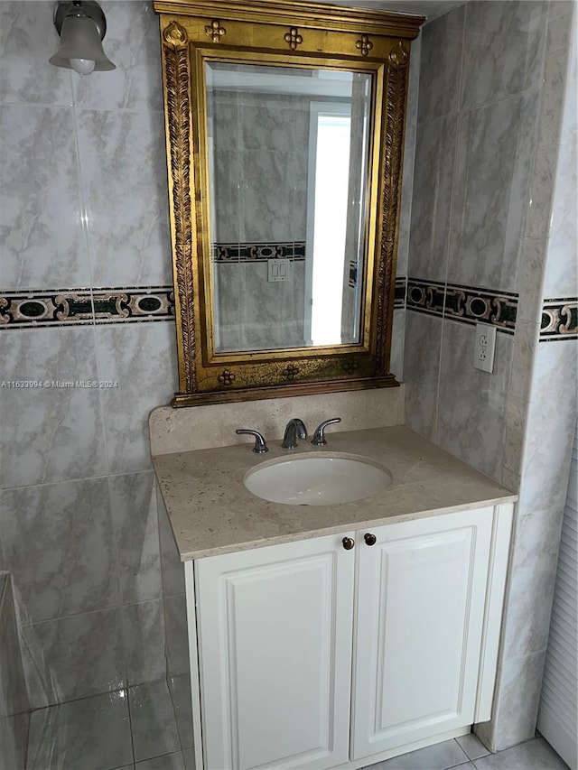 bathroom featuring tile patterned flooring, tile walls, and vanity