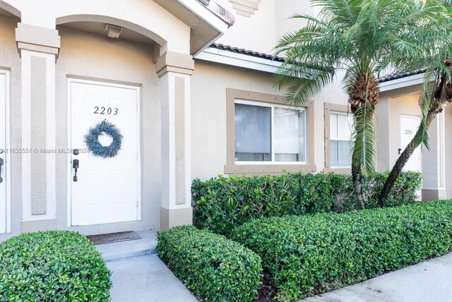 2203 SE 23rd Ter Unit 2203, Homestead, FL 33035 - doorway to property with a tiled roof and stucco siding