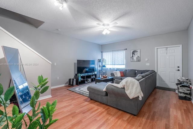 living room with a textured ceiling, hardwood / wood-style floors, and ceiling fan